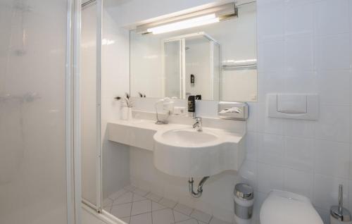 a bathroom with a sink, toilet, and shower stall at Hotel Neutor Express in Salzburg