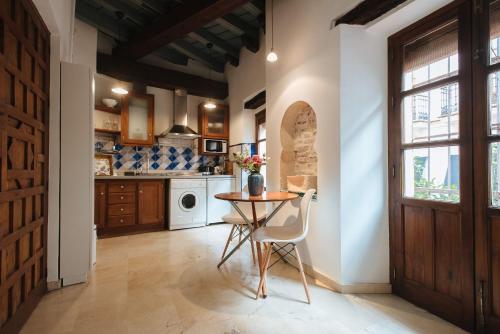 a kitchen with a table and chairs in a room at Boutike Apartments in Seville