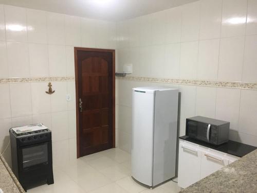 a kitchen with a refrigerator and a stove at Aconchegante Casa de Temporada Araruama in Araruama