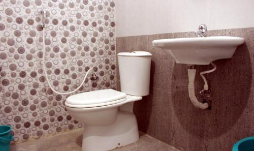 a bathroom with a toilet and a sink at Abirami Residency in kāraikāl