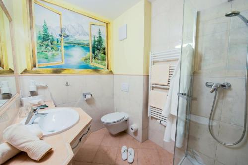 a bathroom with a sink and a toilet and a shower at Hotel Riedl in Kössen