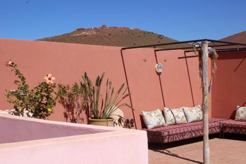 a patio with two couches and plants with a mountain in the background at Tifawin Apartment in Mirleft