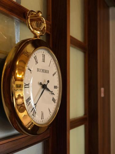 a gold pocket watch is hanging on a door at Olympia Hotel Zurich in Zürich