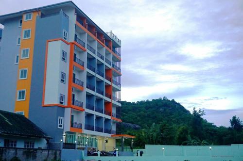 a tall apartment building with a mountain in the background at A.D. Living in Hua Hin