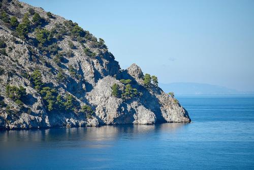 a large cliff in the middle of a body of water at Xenia Residence & Suites in Pili