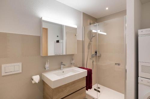a bathroom with a sink and a shower at Andermatt Alpine Apartments in Andermatt