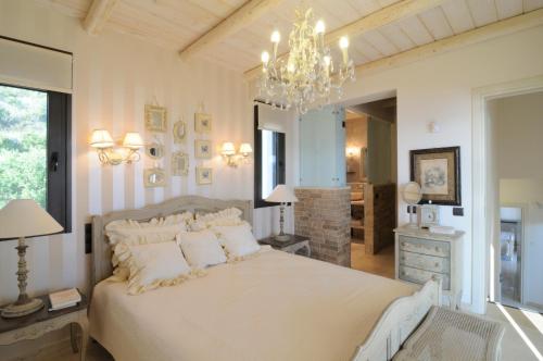 テオロゴスにあるvilla Titinaのベッドルーム(大きな白いベッド1台、シャンデリア付)