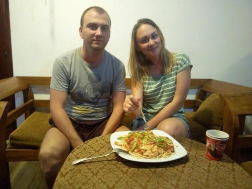 a man and woman sitting at a table with a plate of food at Yuthika Resort in Negombo