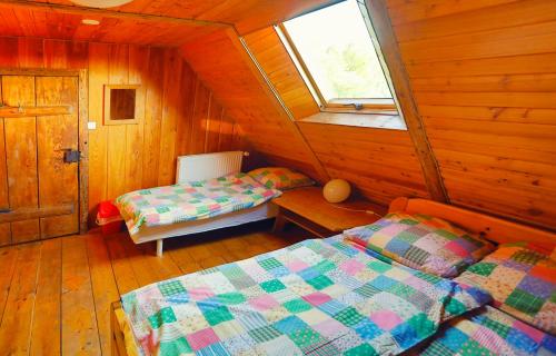 a bedroom with two beds in a wooden cabin at Dom Przysłupowy Educare -Agroturystyka Slow Food in Świeradów-Zdrój