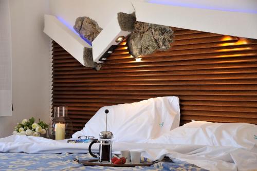a bedroom with a bed with a wooden head board at Residence L'Ea di Lavru - Appartamenti Mono-Bilo-Trilocali in Porto San Paolo