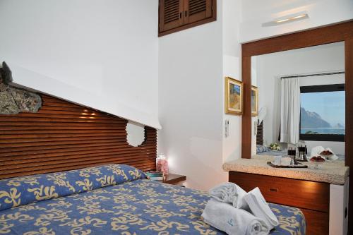 a bedroom with a bed and a sink and a mirror at Residence L'Ea di Lavru - Appartamenti Mono-Bilo-Trilocali in Porto San Paolo