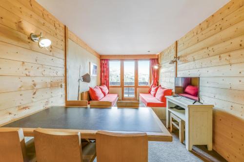un salon avec une table et une télévision dans l'établissement Residence Les Nereides - maeva Home, à Belle Plagne