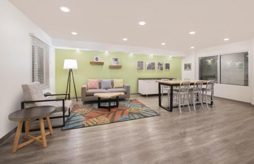 a living room with a couch and a table and chairs at WoodSpring Suites Savannah Pooler in Savannah