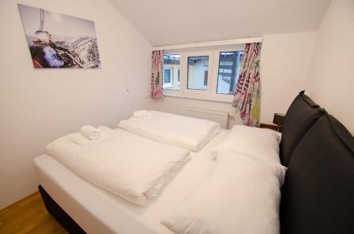 ツェル・アム・ゼーにあるPenthouse SEVEN by All in One Apartmentsのベッドルーム1室(白い枕2つ付)