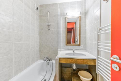 une salle de bain avec une baignoire, un lavabo et des toilettes dans l'établissement Residence Le Quartz - maeva Home, à Belle Plagne