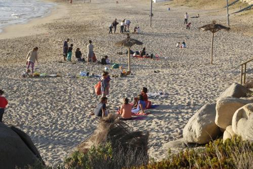 a group of people sitting on a beach at Club Playa Blanca in Playa Blanca