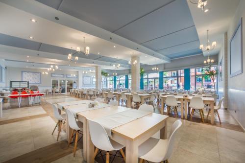 a dining room with tables and chairs and a cafeteria at Delfin in Krynica Morska