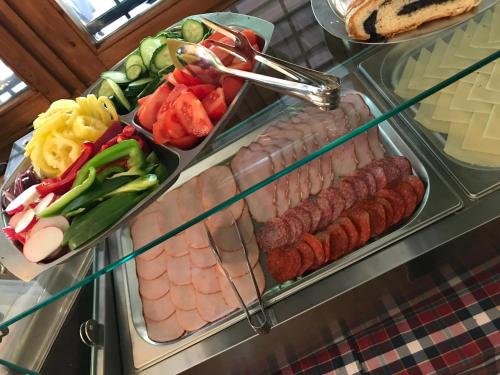 a display case with a variety of meats and vegetables at Hotel Síkfőkút in Noszvaj