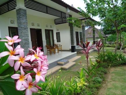 a house with pink flowers in front of it at Bingin Family Bungalow in Uluwatu