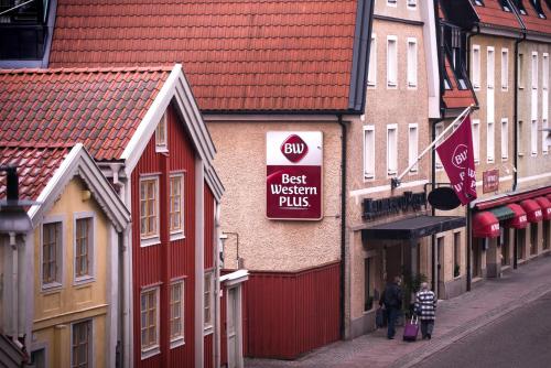 a couple of people walking down a street next to buildings at Best Western Plus Kalmarsund Hotell in Kalmar
