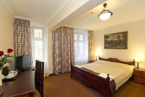 a bedroom with a bed and a television in it at Hotel Retman in Toruń