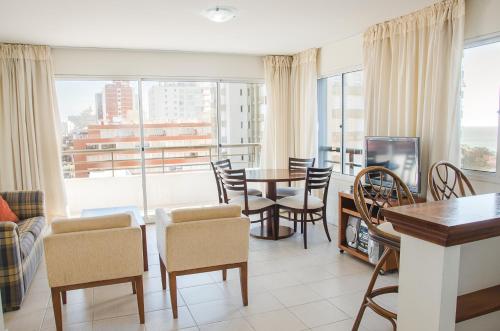 a living room with a table and chairs and a large window at Hotel Sunset Beach in Punta del Este