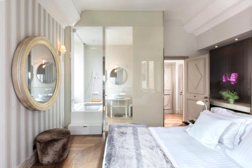 a bedroom with a large bed and a bathroom at Hotel Palazzo Manfredi – Small Luxury Hotels of the World in Rome