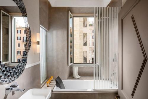 a bathroom with a tub and a sink and a mirror at Hotel Palazzo Manfredi – Small Luxury Hotels of the World in Rome