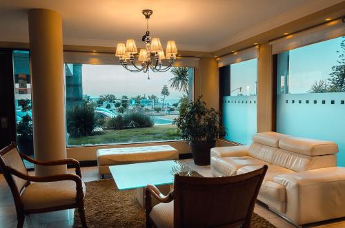 a living room with a chandelier and a table and chairs at Hotel Sunset Beach in Punta del Este