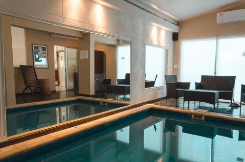 a swimming pool in a room with a table and chairs at Hotel Sunset Beach in Punta del Este