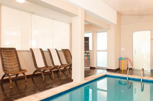 una piscina con sillas junto a una piscina en Hotel Sunset Beach, en Punta del Este
