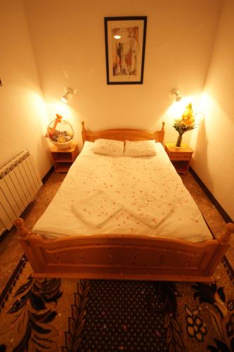 a large bed in a bedroom with two lamps at Zajazd Wrota Lasu in Hajnówka