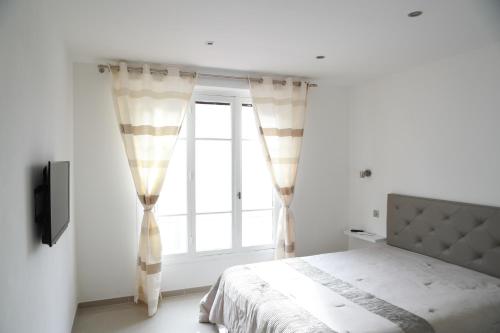 1 dormitorio con cama y ventana en 3P luxe proche Croisette en Cannes