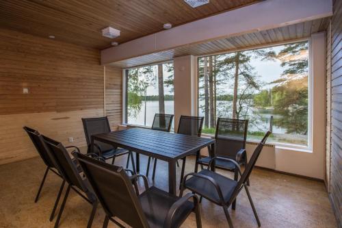 a dining room with a table and chairs and a large window at Hotelli Salpa in Luumäki
