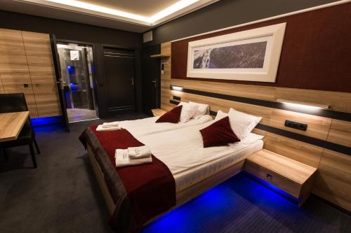 a bedroom with a large bed with white sheets and red pillows at Villa Winterpol in Karpacz