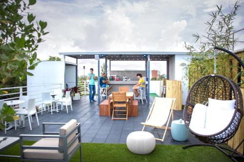 a rooftop patio with chairs and a bar at Nomada Urban Beach Hostel- Calle Loiza in San Juan
