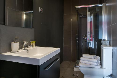 a bathroom with a sink and a shower and a toilet at Virgo - Loft with Spectacular View to Acropolis in Athens
