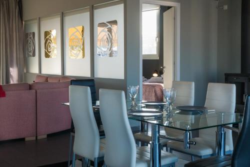a dining room with a glass table and white chairs at Virgo - Loft with Spectacular View to Acropolis in Athens
