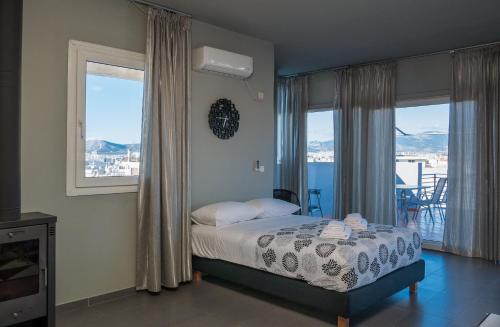 a bedroom with a bed and windows with a view at Virgo - Loft with Spectacular View to Acropolis in Athens