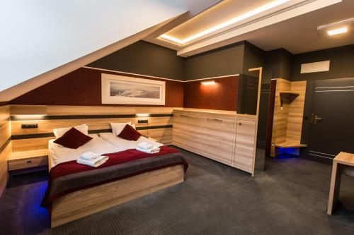 a bedroom with a large bed and a staircase at Villa Winterpol in Karpacz