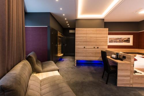a living room with a couch and a bed and a desk at Villa Winterpol in Karpacz