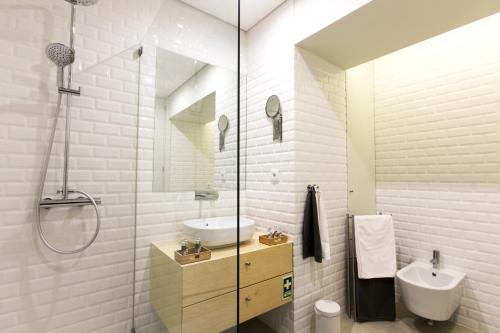 a white bathroom with a sink and a shower at Porto Nascente in Porto