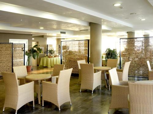 ein Restaurant mit weißen Stühlen und Tischen und ein Zimmer mit einem Tisch in der Unterkunft Casa Del Mar in Roseto degli Abruzzi