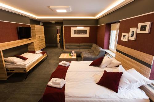 a hotel room with two beds and a couch at Villa Winterpol in Karpacz