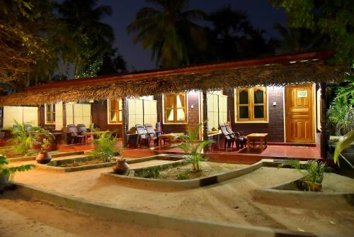 a small house with a straw roof at Naaval Beach Villa & Rooms in Batticaloa