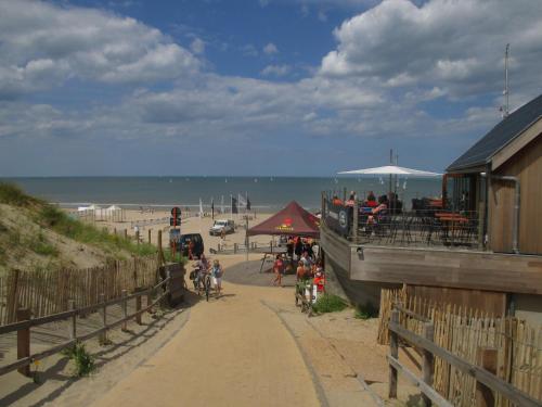 a beach with a restaurant and people on a sidewalk at Studio On The Beach With Sea View in Middelkerke