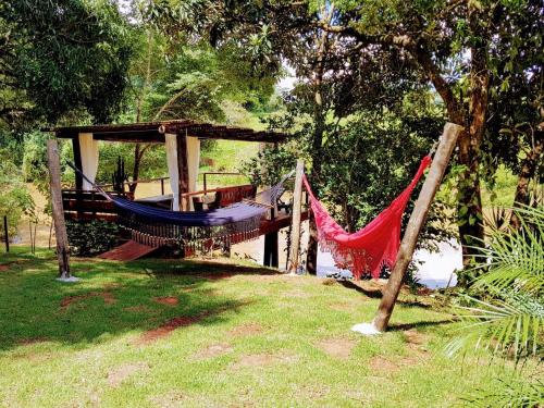 a hammock in a park next to a body of water at Pousada Santa Thereza in Serra Negra