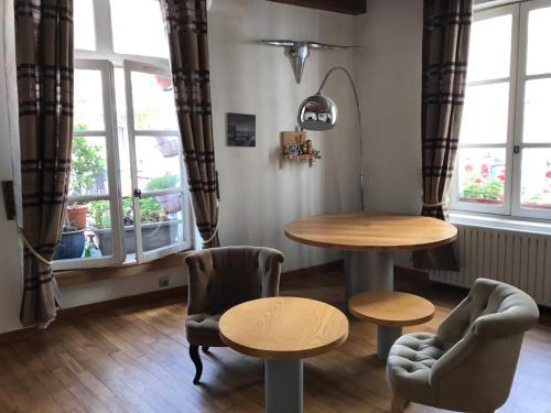 une table et des chaises dans une pièce avec des fenêtres dans l'établissement Quartier Montorgueil, voie piétonne, dans un immeuble du XVème, à Paris