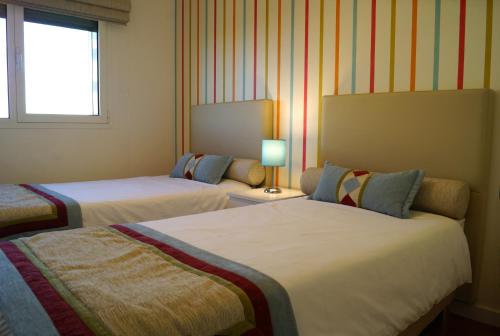 リスボンにあるWelcome Here - Danubio - Parque das Naçõesのベッド2台と窓が備わるホテルルームです。