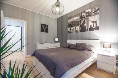 グダニスクにあるTricity Apartments - Mila Balticaのベッドルーム(ベッド1台、鉢植えの植物付)